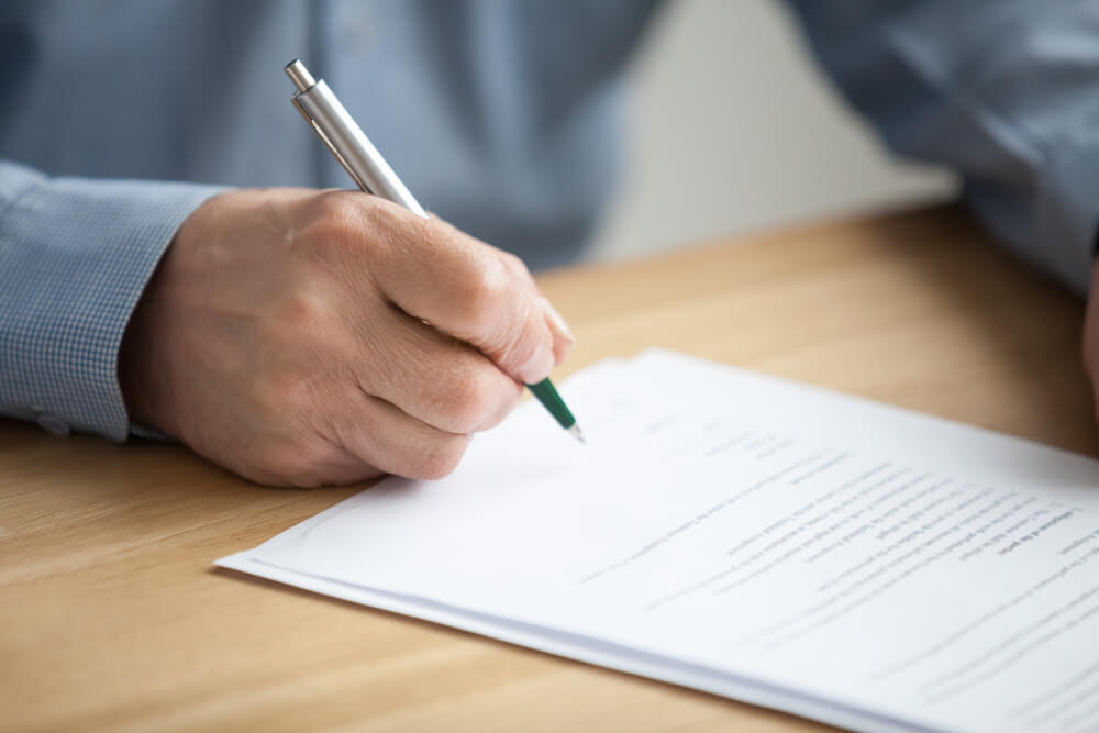 Older Male Hand Signing Business Document Older Male Hand Signing Business Document
